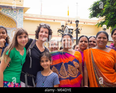 Reisende - Mutter und ihre beiden Töchter stehen mit Einheimischen Stockfoto