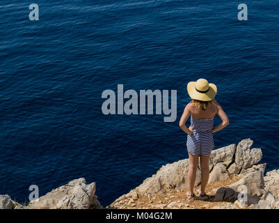 Mädchen auf einer Klippe am Meer. Stockfoto