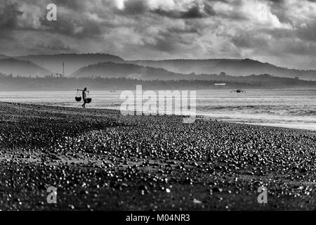 Indonesische Salz Landwirt von Kusamba Salz Bergbau Dorf auf Bali sammeln Meer Wasser in den Morgen für Salz produziert nach der traditionellen Methode Stockfoto