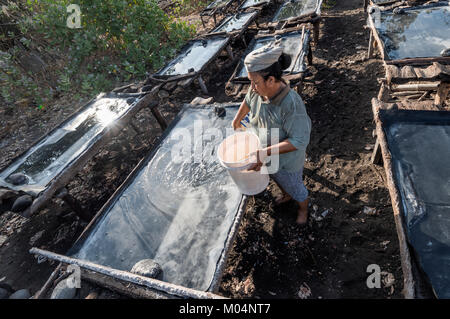 Indonesische Salz Landwirt von Kusamba Salz Bergbau Dorf auf Bali sammeln Meer Wasser in den Morgen für Salz produziert nach der traditionellen Methode Stockfoto