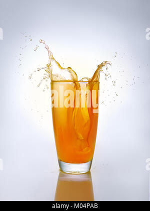 Orangensaft splash in Glas Stockfoto