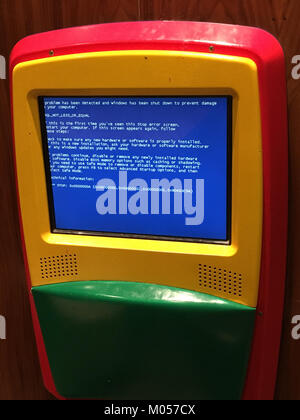 Dieses Bild zeigt eine Fehlermeldung auf dem Blue Screen of Death (BSoD), die auf einem Computer in einem McDonald's Restaurant angezeigt wird. Die Fehlfunktion symbolisiert häufige technische Probleme, die in öffentlichen Räumen mit moderner Technologie auftreten. Stockfoto