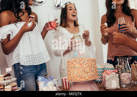 Gerne erwarten Baby und mit Freunden. Gruppe von Frauen, die Essen und Trinken zu Babyduschepartei. Stockfoto