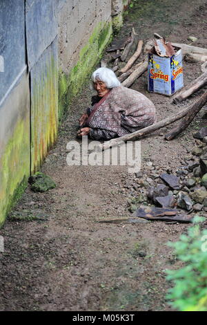 Batad, Philippines-October 7, 2016: Gebuckelt alte Frau der Ifugao die Leute viel arbeitet an der Außenseite von ihrem Haus in Batad Weiler - Reis Terrassen der Stockfoto