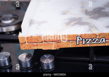 Verwendete Pappe pizza box mit Fettflecken lesft auf dem Boden Stockfoto