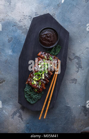 Grill Schweinerippchen auf Holzbrett, Ansicht von oben. Stockfoto