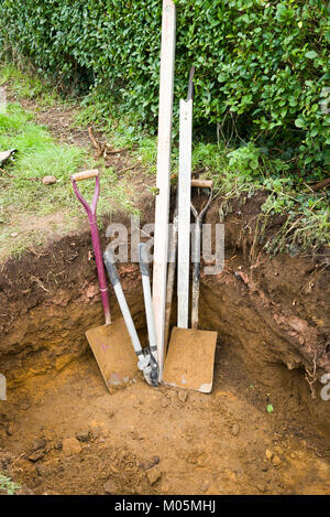 Werkzeuge in teilweise soakaway Grube gegraben, bereit für die nächste Arbeitssitzung in Großbritannien Stockfoto