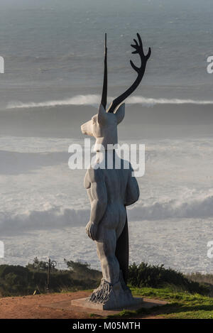"Veado' Surfer mit einem Hirsche Kopf statue am Praia do Norte in Nazaré, von Bildhauer Adália Alberto, Nazaré, Portugal Stockfoto