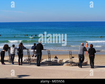 Menschen, die auf der Promenade beobachten wave Surfer an der See an einem perfekten Tag mit strahlend blauem Himmel Stockfoto