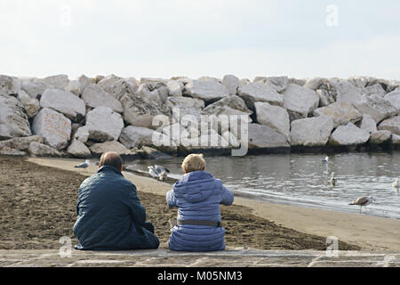 Paar am Strand sitzen Stockfoto