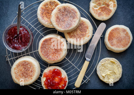 Englische Muffins mit Erdbeermarmelade auf einer Schiefertafel Hintergrund Stockfoto