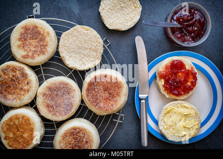 Englische Muffins mit Erdbeermarmelade auf einer Schiefertafel Hintergrund Stockfoto