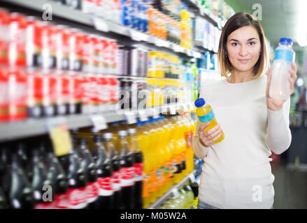 Glückliche Frau Wahl erfrischende Getränke im Supermarkt Stockfoto