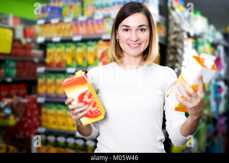 Lächelnden jungen Mädchen auf der Suche nach Getränken im Supermarkt Stockfoto