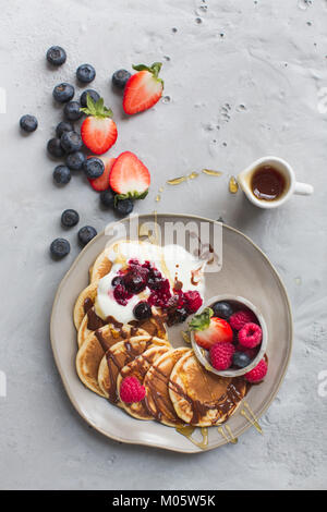 Pfannkuchen mit frischen Obst und Schokoladensauce und Ahornsirup Stockfoto