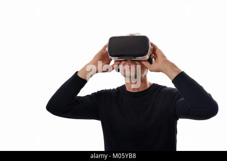 Lächelnder Mann mit schwarzen Pullover und Virtual reality Brillen mit Gläsern, oben zu schauen. Weiß isoliert Stockfoto