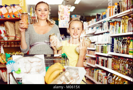 Gerne heiter froh Mutter mit Jugendmädchen Demonstration ihrer Wahl in Essen Abteilung im Supermarkt Stockfoto