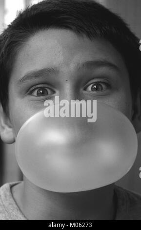 Ein Kind macht einen Ballon mit einer Bubble gum Stockfoto