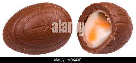 Dieses Bild zeigt ein ganzes und geteiltes Cadbury Creme Egg, ein beliebtes saisonales Schokoladenprodukt, das für seine cremige Füllung bekannt ist. Es hebt die Struktur und Verpackung des Leckerlis hervor, das während der Osterzeit häufig konsumiert wird. Stockfoto
