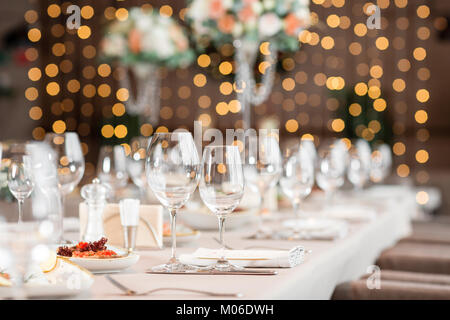 Fokus auf Gläsern. Bankett Tisch im Restaurant, die Vorbereitung vor dem Bankett. die Arbeit von professionellen Floristen. Stockfoto