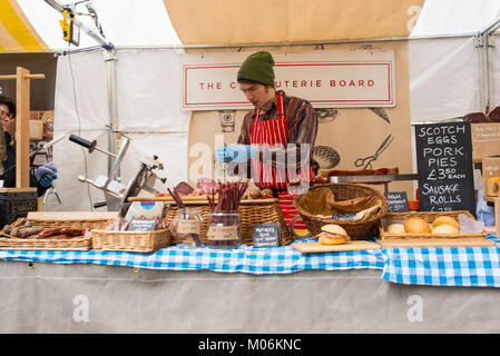 Hipster charcuterie Stall gepökeltes Fleisch und Wurst rollen unter dem Vordach Markt, King's Cross, London. Vordach Markt ist ein Pop-up-Markt in der Nähe von Grana Stockfoto