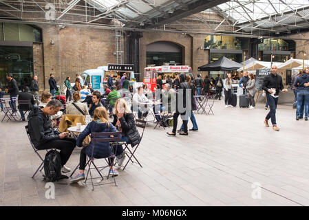 Menschen essen und sitzen im Innen bereich der Haube Markt, King's Cross, London. Vordach Markt ist ein Pop-up-Markt in der Nähe von kornhaus Platz whith Va Stockfoto