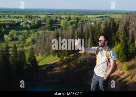 Stilvolle Jüngling mit einem Bart Sonnenbrille macht Selfie auf der Canyon-Klippe Stockfoto
