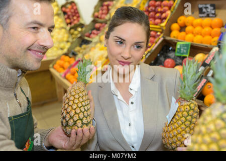 lächelnde Frau Wahl verschiedener Früchte am Bauernhof Food Store-display Stockfoto