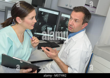 Mrt-Maschine und Bildschirme mit Arzt und Krankenschwester Stockfoto