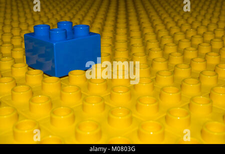 Ein Meer von gelben Gebäude Ziegel alle ligned so weit wie das Auge sehen kann, mit einem einsamen Blauen Block saß oben auf. Stockfoto
