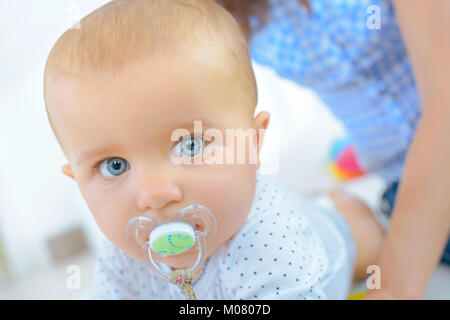 Portrait von Baby mit Schnuller im Mund Stockfoto