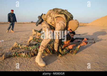 Ein spanischer Soldat Trainer ein irakischer Soldat 25 Bataillon Anbar Polizei zugewiesen, während Treffsicherheit Training im Camp Besmaya, Irak Jan. 7, 2018. Die Schulung ist Teil des gesamten Combined Joint Task Force - inhärenten Building Partner Kapazität mission lösen, die über die Ausbildung und die Verbesserung der Fähigkeit der zusammengeschlossen, um Kräfte, die ISIS konzentriert. CJTF-OIR ist die globale Koalition zu besiegen ISIS im Irak und in Syrien. (U.S. Armee Stockfoto