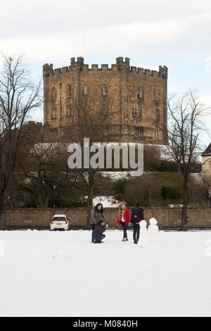 Weibliche Durham University Studierende mit Foto von zwei schneemänner auf Palast Grün vor Durham Castle, Durham, England, Großbritannien Stockfoto