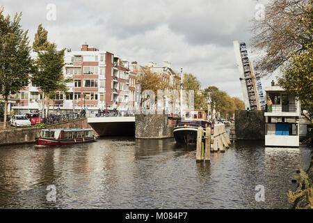 Barge, die durch eine Klappbrücke über Hortusbrug Nieuwe Herengracht Kanal, Amsterdam, Niederlande Stockfoto