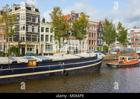 Tug Boat Führen einer Barge entlang Nieuwe Herengracht Kanal, Amsterdam, Niederlande Stockfoto