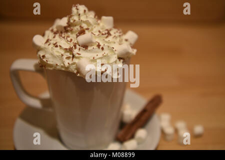 Essen und Trinken fotografie Bild einer frischen home Hot Chocolate Drink in eine weiße Tasse oder Becher mit Schlagsahne und Marshmallows auf rustikalen Holz Stockfoto
