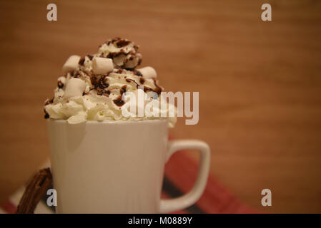 Essen und Trinken fotografie Bild einer frischen Hot Chocolate Drink in eine weiße Tasse bzw. Becher garniert mit Sahne mini Marshmallows und Schokolade Stockfoto