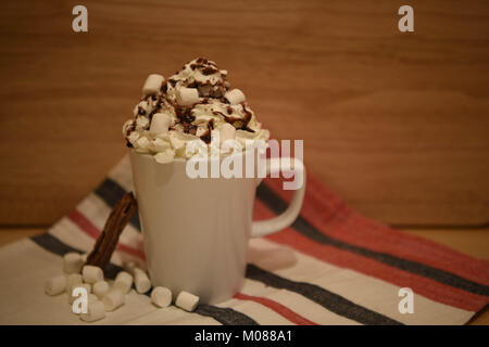 Essen und Trinken fotografie Bild einer frischen Hot Chocolate Drink in eine weiße Tasse bzw. Becher garniert mit Sahne mini Marshmallows und Schokolade Stockfoto