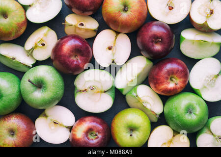 Rote und grüne Äpfel auf einer Schiefertafel Hintergrund Stockfoto
