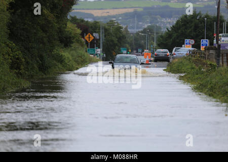 Auto Automobil fahren durch einen tiefen Überflutete Straße nach Sintflutartigen lief, County Kerry, Irland, Stockfoto