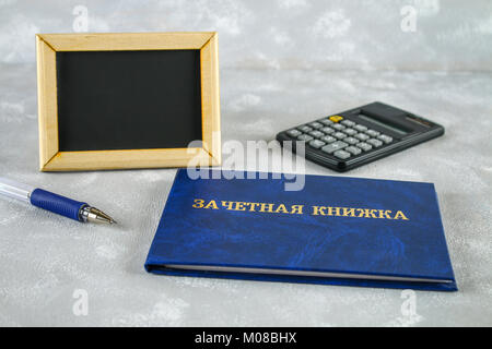 Ein blaues Buch mit einer Inschrift in Russisch - ein Student Record Book. Pen, Rechner auf einem grauen Hintergrund. Students' Tag. Platz kopieren Stockfoto