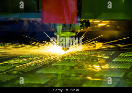 Leiter der CNC-Laser cutiing Maschine mit Funkenbildung Strahl behine Sicherheitsglas. Stockfoto