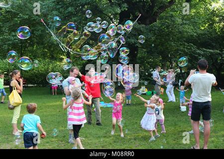 WROCLAW, Polen - Juli 6, 2014: Kinder spielen mit Seifenblasen in Park in Breslau. Breslau ist die viertgrößte Stadt in Polen mit 632,067 Menschen (201 Stockfoto
