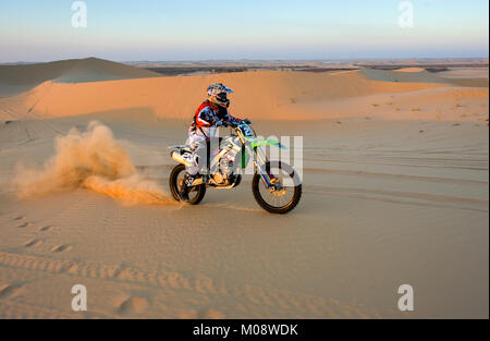 ABU DHABI, VEREINIGTE ARABISCHE EMIRATE - Jan 01, 2018: ein Mann auf einem Dirt Bike ist Reiten auf dem Hügel in der Wüste in den Vereinigten Arabischen Emiraten. Stockfoto