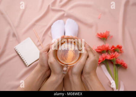 Liebe oder der Valentinstag Konzept. Womans und mens Hände, die heiße Tasse Tee Stockfoto