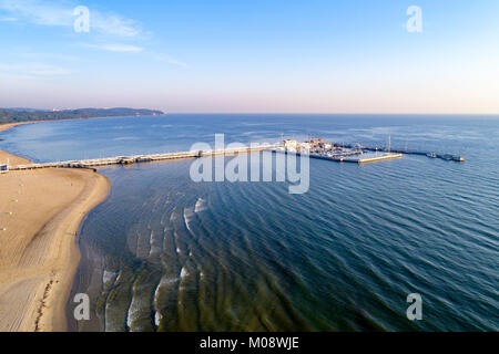 Sopot Resort in Polen. Hölzerne Seebrücke (Molo) mit Marina, Yachten, Pirate touristische Schiff und Strand, weit Ansicht von Gdynia. Luftbild bei Sonnenaufgang. Sopot res Stockfoto