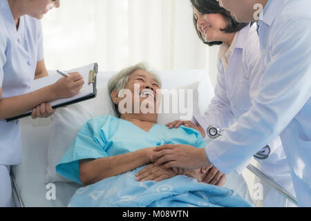 Asiatische medizinische Team von Ärzten untersucht und im Gespräch mit asiatischen ältere Frau patient, Gesundheit Menschen bemerken auf Zwischenablage im Krankenhaus. Stockfoto