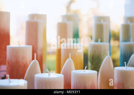Viele stehen bunte Kerzen mit Dochten leuchtet durch Sonnenlicht mit unscharfen Hintergrund Stockfoto