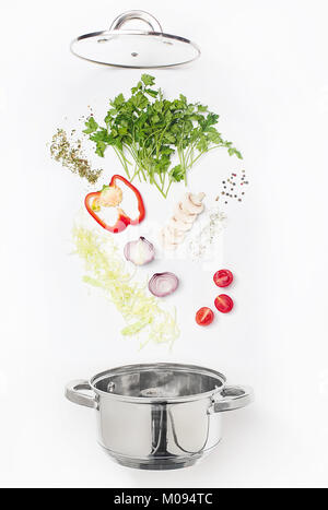 Verschiedene frische Gemüse in eine Schüssel fallen, auf weißem Hintergrund Stockfoto