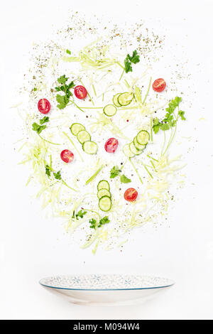 Der Salat Schüssel im Flug mit Gemüse: Tomaten, Gurken, Kohl auf weißem Hintergrund Stockfoto